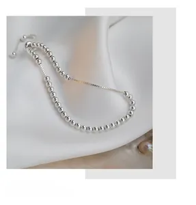 Detailed close-up of S925 sterling silver beads with adjustable drawstring clasp on silk