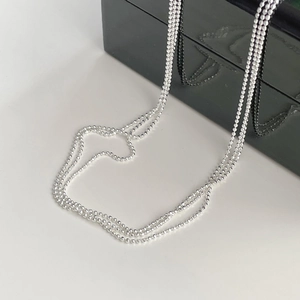 Detailed macro view of sparkling S925 sterling silver beads on a multi-layer chain