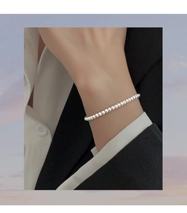 Close-up of a minimalist S925 sterling silver beaded bracelet on a woman wrist
