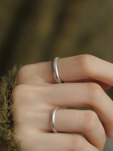 Close-up of minimalist S925 sterling silver matte couple rings on model's fingers