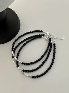 Detail of three black onyx bead bracelets with silver tube spacers and lobster clasp closure