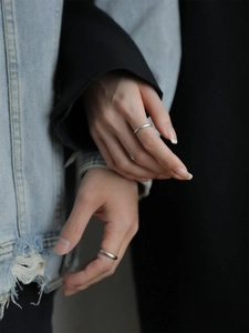 Macro shot of minimalist matte S925 sterling silver couple rings on models' hands