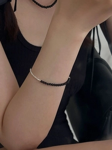 Detailed close-up of S925 silver beaded bracelet with black onyx stones on female wrist