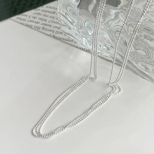 Macro detail of shimmering S925 sterling silver beaded necklace on aesthetic background