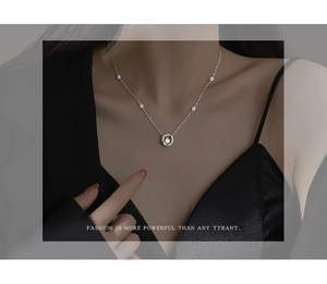 Close-up of S925 sterling silver Mobius necklace with sparkling zircon pendant on model