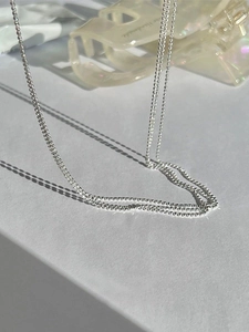 Macro shot of minimalist S925 sterling silver beaded chain necklace with subtle shadow