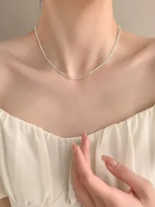 Close-up of triple-layered S925 sterling silver beaded necklace worn on a female neck