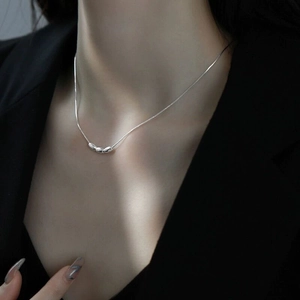 Macro shot of S925 sterling silver triple bean pendant necklace on model neck