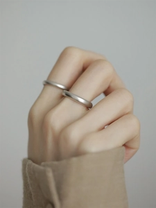 Close-up of minimalist S925 sterling silver matte rings worn on hand for couples