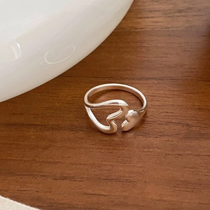 Detailed macro view of S925 sterling silver hollow heart ring on a rustic wooden surface