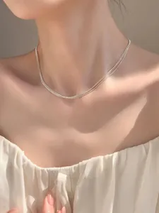 Detailed view of triple-layered 925 sterling silver beaded chain necklace on model