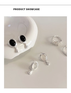 Détail des boucles d'oreilles rétro en argent S925, onyx noir et pierre de lune sur décor