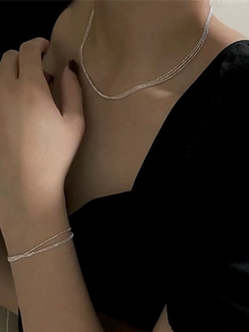 Close-up of a triple-layer S925 sterling silver chain necklace on a model