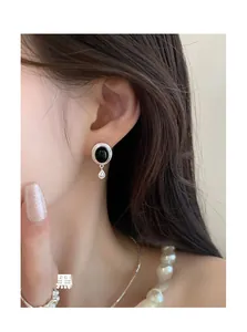 Détail de la boucle d'oreille en argent S925 avec onyx noir portée sur un modèle