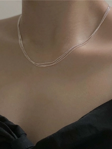 Close-up of a delicate S925 sterling silver beaded chain necklace worn on the neck