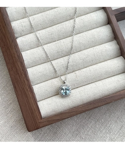 Macro view of S925 silver necklace with square blue zircon pendant and halo diamond setting