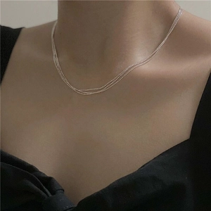 Close-up of triple-layered S925 sterling silver beaded necklace on model's neck
