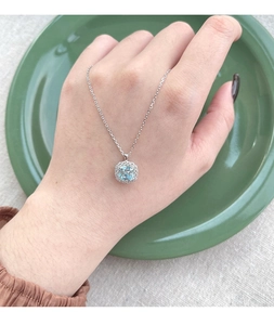 Close-up of S925 silver necklace with square sea blue zircon pendant on a model