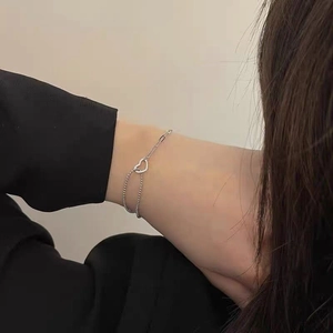 Close-up of S925 sterling silver hollow heart bracelet with mixed chain design on wrist