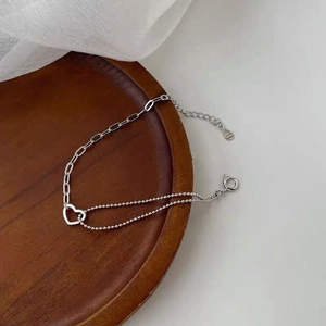 Detail of S925 sterling silver double-layer bracelet with hollow heart pendant