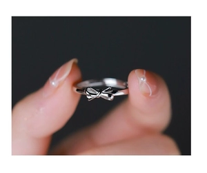 Close-up of S925 sterling silver bow ring featuring a minimalist design on a finger