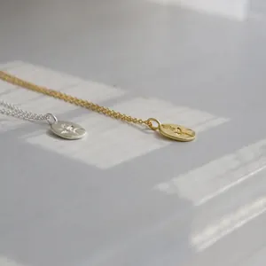 Dettaglio di collane con ciondolo a rosa ovale in argento S925 e oro con ombra elegante