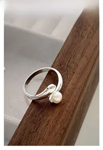 Detailed view of an S925 sterling silver ring featuring a white pearl and curved band