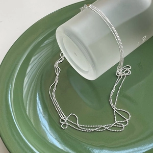 Minimalist S925 sterling silver beaded chain necklace on a green ceramic plate
