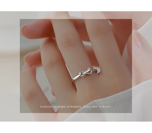 Detail of S925 sterling silver bow ring worn on finger featuring a delicate ribbon design