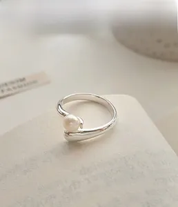 Detailed view of an S925 silver ring featuring a round white pearl on a textured base