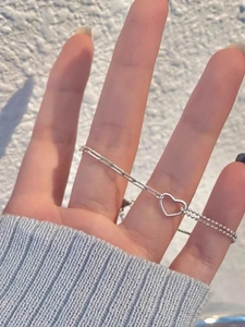 Detailed shot of S925 sterling silver bracelet featuring hollow heart charm and mixed links