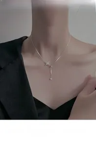 Detail of S925 sterling silver star pendant necklace worn by a model in black attire