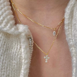 Detail einer zweischichtigen Goldhalskette mit Kreuz und Marquise-Zirkonia am Modell
