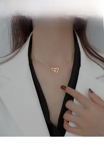 Detailed view of gold interlocking heart necklace on neck with adjustable extension chain