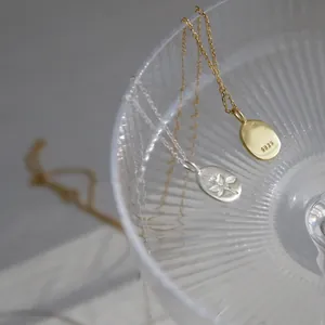 Primo piano del ciondolo a rosa in argento S925 che mostra il marchio e i dettagli a rilievo