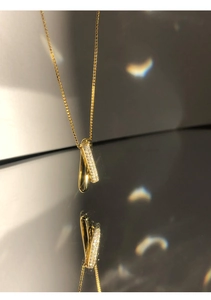 Detail of 18K gold geometric interlocking circles necklace with shimmering micro-pave zircons