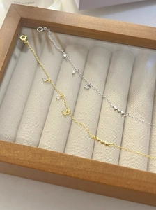Close-up of gold and silver S925 sterling silver bracelets with pavé heart charms
