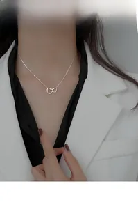 Detail of S925 sterling silver interlocking heart necklace worn by a model on a suit