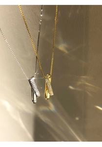 Detail of interlocking S925 silver and gold geometric necklaces with cubic zirconia inlay