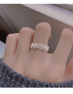 Close-up of S925 sterling silver open ring with hollow flower design on a finger