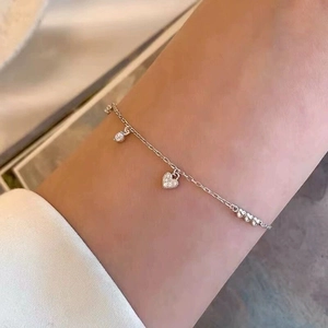 Detailed close-up of S925 sterling silver bracelet with sparkling heart and zircon charms