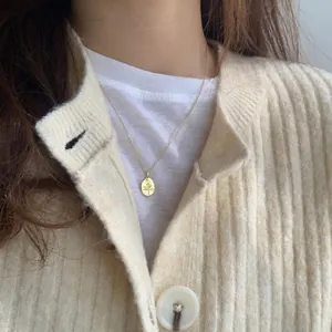 Collana minimalista in argento S925 con pendente a rosa dorata indossata da modella