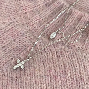 Makro-Detail einer S925 Silber Doppel-Halskette mit Kreuz und Marquise-Schliff Stein