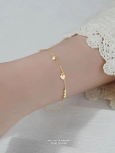 Detail of S925 silver heart bracelet with white zircon on a woman's wrist with lace