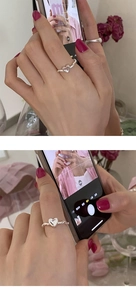 Close-up of S925 silver heart ring with twisted rope band shown in mirror selfie