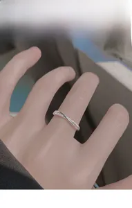 Close-up of S925 sterling silver criss-cross ring with white zircon stones on a model finger