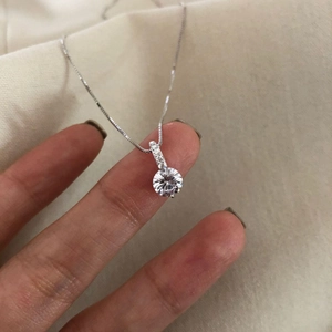 Detailed macro view of S925 silver necklace with single solitaire diamond pendant on box chain