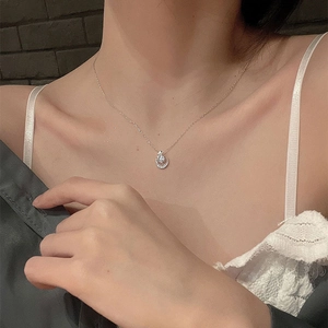 Close-up of S925 sterling silver star and moon pendant necklace worn by a model