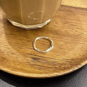 Detailed view of S925 silver ring featuring Luck engraving on a rustic wooden tray