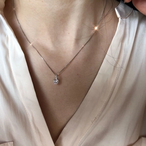 Detail of S925 sterling silver necklace with single sparkling zircon pendant on model